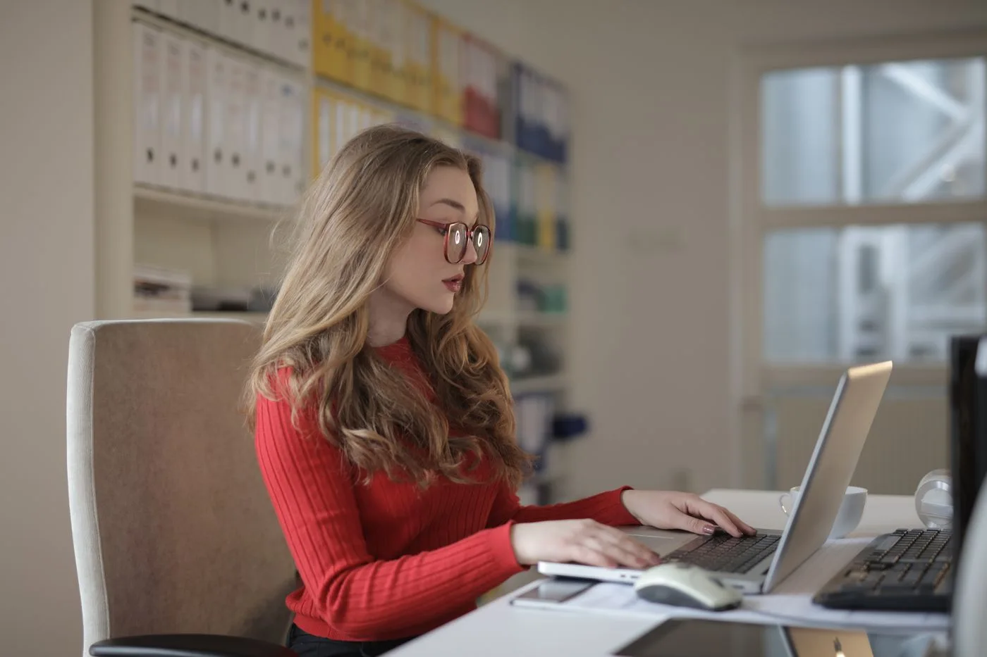 A woman working at a laptop in a quiet office