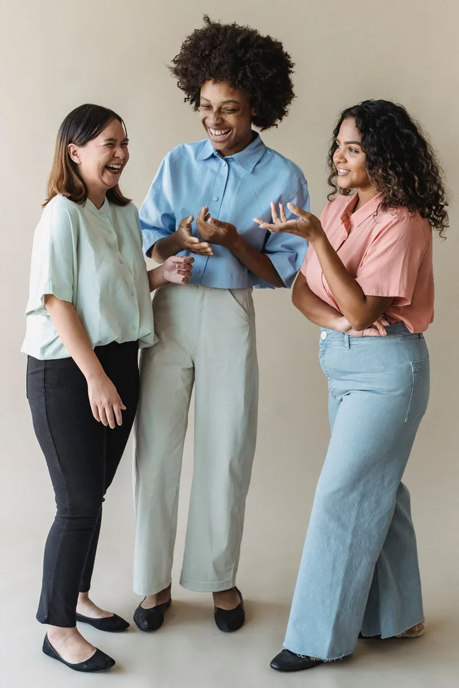 Three women sharing a conversation indoors