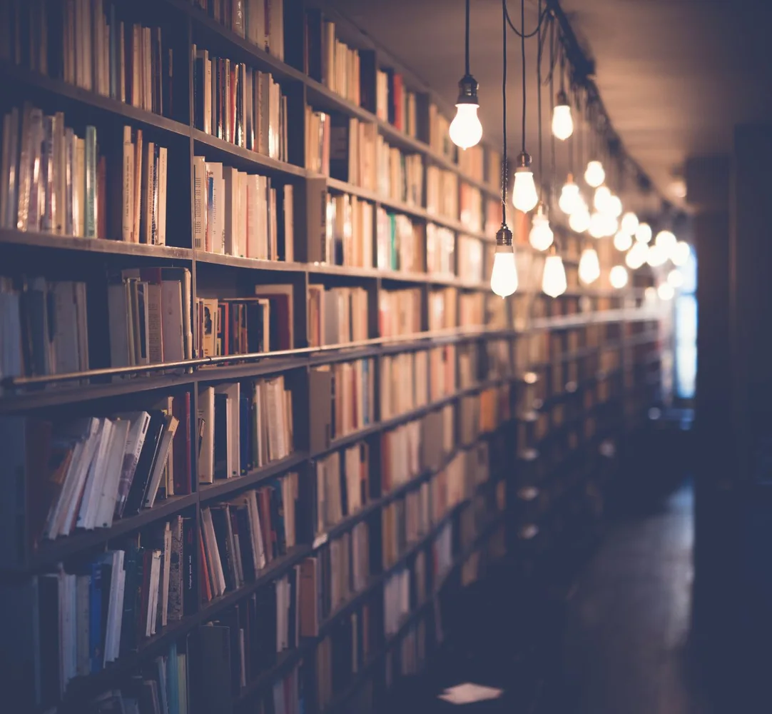 Warm light illuminating rows of books in a library