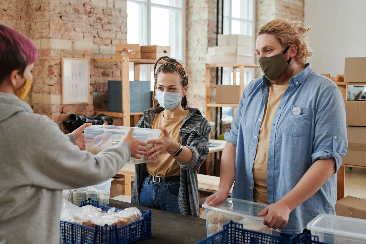 Volunteers handing out groceries at a food donation table